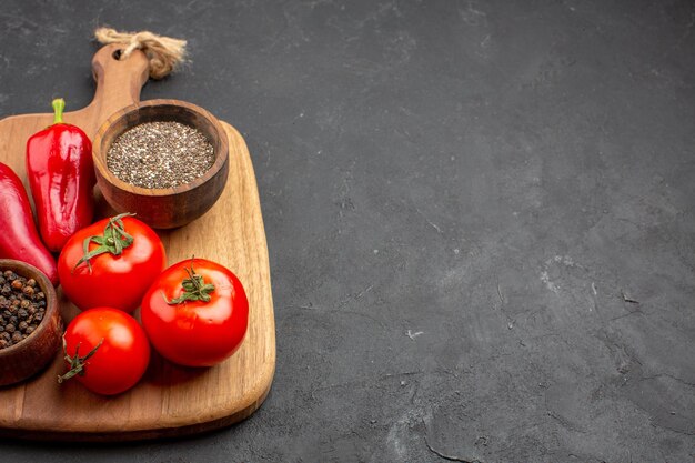 Front view fresh red tomatoes with seasonings on the dark space