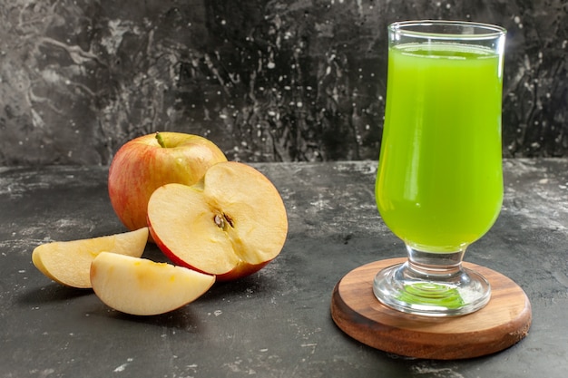 Вид спереди свежее спелое яблоко с зеленым яблочным соком на темном спелом соке дерева фото цвет