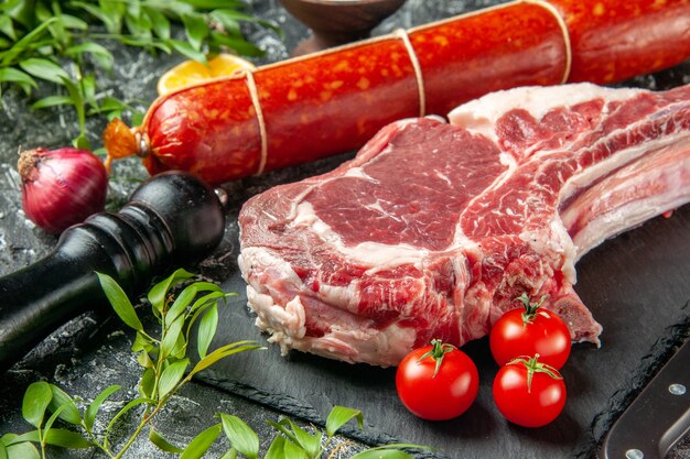 トマトとミートスライスを明暗のサンドイッチに載せた新鮮なソーセージの正面図肉料理パンミールカラーアニマルバーガー