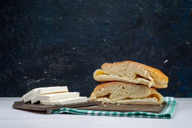 正面の新鮮なスライスされたパンと暗闇の中で白いチーズ