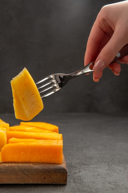 Foto gratuita vista frontale formaggio fresco a fette sulla forchetta colore scuro snack foto colazione patatine pasto