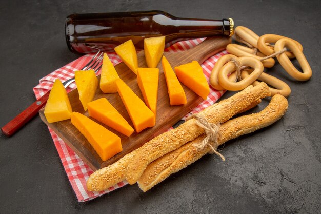 正面から見た新鮮なスライス チーズとパンとクラッカーがダーク グレー色の食事の写真の朝食の cips 食品クリスプ