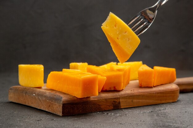 正面から見た新鮮なスライス チーズ、暗いスナックの食事の色の朝食のクリスプにバンズ