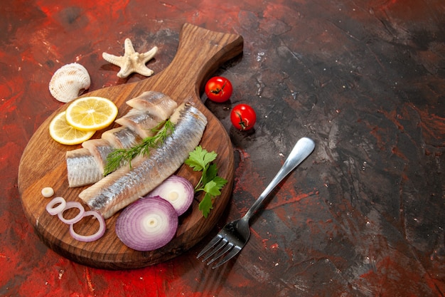 暗いシーフード カラー サラダ肉スナックにオニオン リングと新鮮なスライスした魚の正面図
