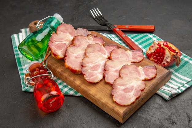 Front view fresh sliced ham on wooden desk and grey food photo raw pig color