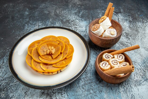 Front view of fresh sliced persimmons inside plate on dark surface