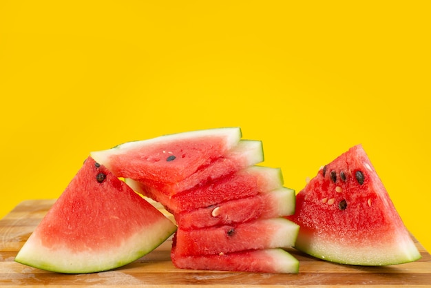 A front view fresh sliced watermelon mellow and juicy on yellow, fruit summer color