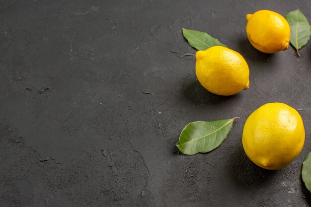 Front view fresh sour lemons lined on dark background