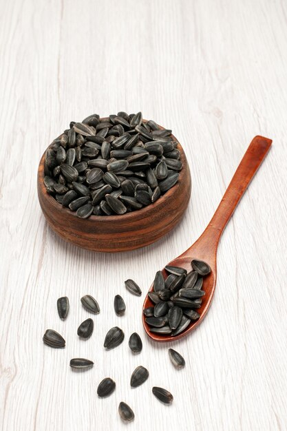 Front view fresh sunflower seeds black seeds on white desk many seed oil plant bag