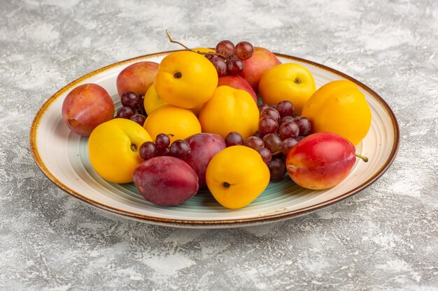 Front view fresh sweet apricots with plums and grapes inside plate on white desk