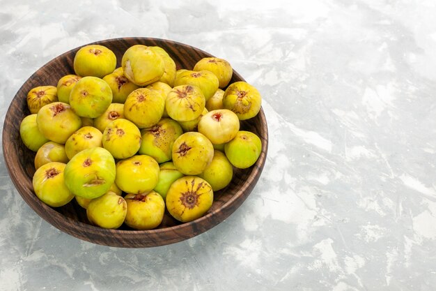 Front view fresh sweet figs inside brown plate on light desk