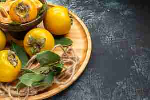 Free photo front view fresh sweet persimmons on a dark background