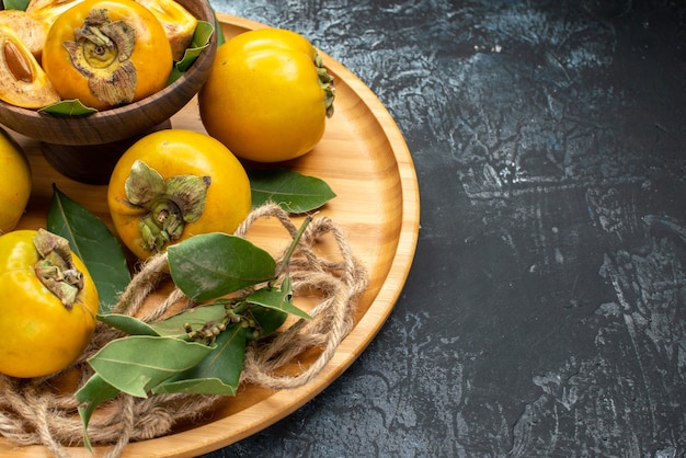 Front view fresh sweet persimmons on a dark background