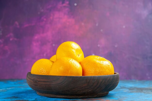 Front view fresh tangerines inside plate on blue-pink table