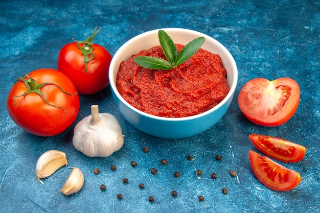 Foto gratuita vista frontale pomodori freschi con concentrato di pomodoro su insalata di colore blu albero rosso cibo vegetale maturo