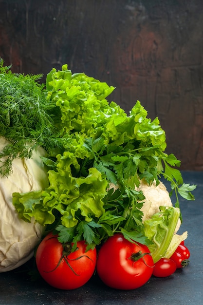 Front view fresh vegetables cabbage parsley bell peppers lettuce dill cauliflower tomatoes on dark isolated surface