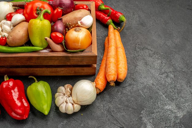 暗いテーブルの熟したサラダの色の健康にコショウとニンニクと新鮮な野菜の正面図