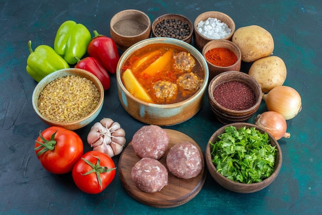 Front view fresh vegetables with seasonings meat soup and greens on dark-blue surface vegetable food meal dish