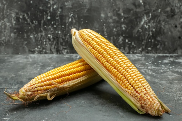 Free photo front view fresh yellow corns on dark background