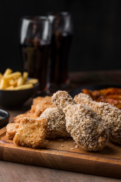 Front view of fried chicken legs with fizzy drinks