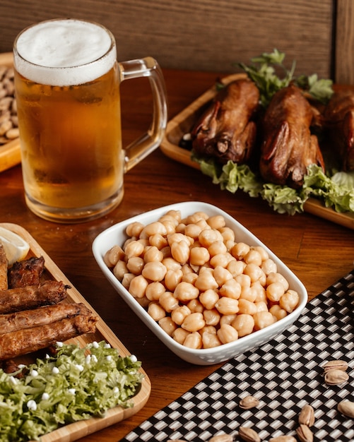 茶色の木製デスクスナックナット食品食事の正面図ビールとナッツの肉のフライ