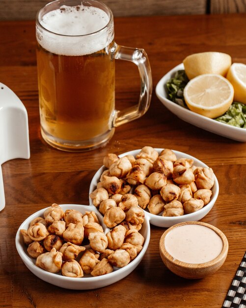 A front view fried snacks with salt lemon and beer on the brown wooden desk food meal snack