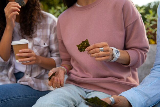 Free photo front view friends eating seaweed snacks