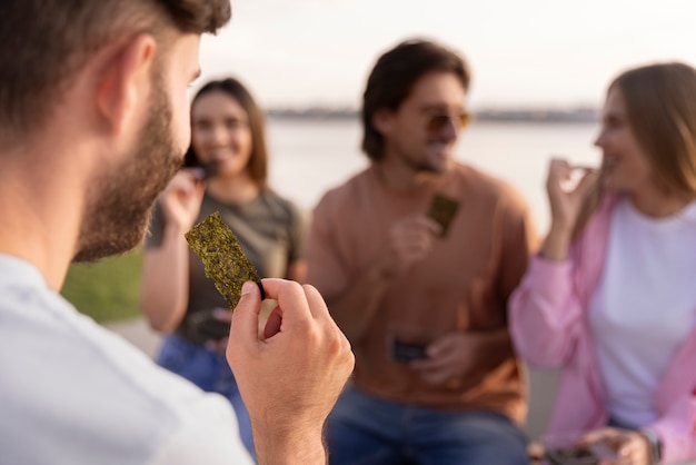 Foto gratuita amici di vista frontale che mangiano spuntini alle alghe