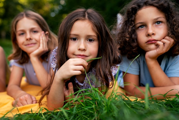 Free photo front view friends laying on grass