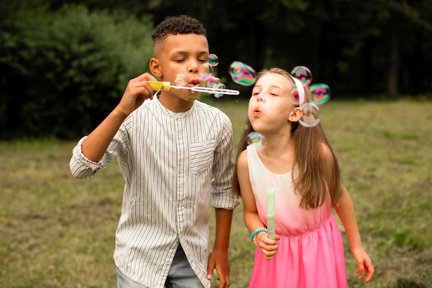 Front view of friends making soap bubbles