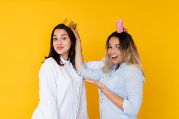 Front view of friends taking selfies with crown