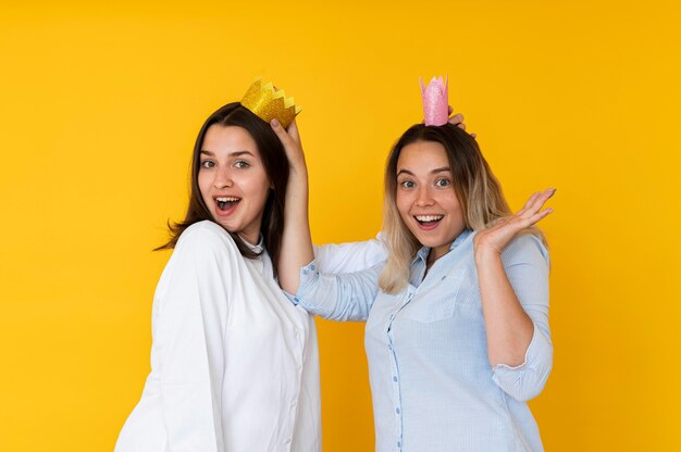 Front view of friends taking selfies with crown