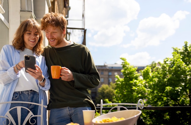 Foto gratuita vista frontale amici con smartphone all'aperto