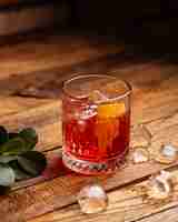 Free photo a front view fruit cocktail with ice-cubes on the brown wooden desk cocktail drink juice