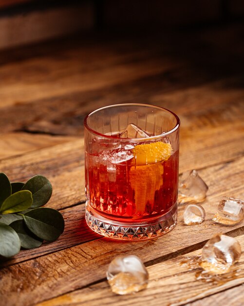 A front view fruit cocktail with ice-cubes on the brown wooden desk cocktail drink juice