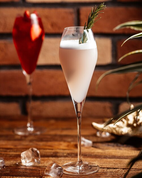 A front view fruit cocktails inside glasses on the brown wooden desk cocktail dessert fruit