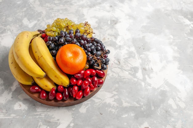 Вид спереди фруктовая композиция, бананы, кизил и виноград на белом столе, фрукты, ягодная свежесть, витамин