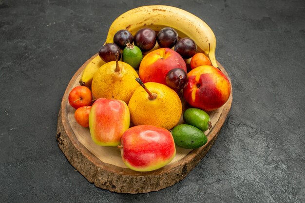 Вид спереди фруктовая композиция свежие фрукты на сером цвете стола спелые много свежих