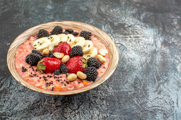 Muesli fruttato vista frontale con frutta a fette sul cereale per la colazione salute tavolo scuro