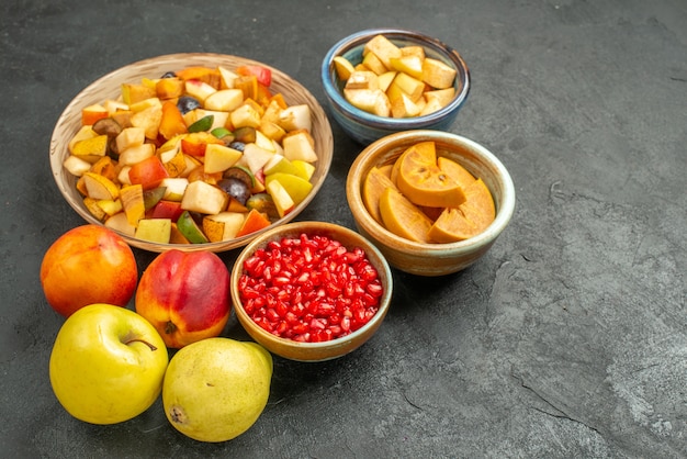 Front view fruity salad with fresh sliced fruits on dark table many fruit health