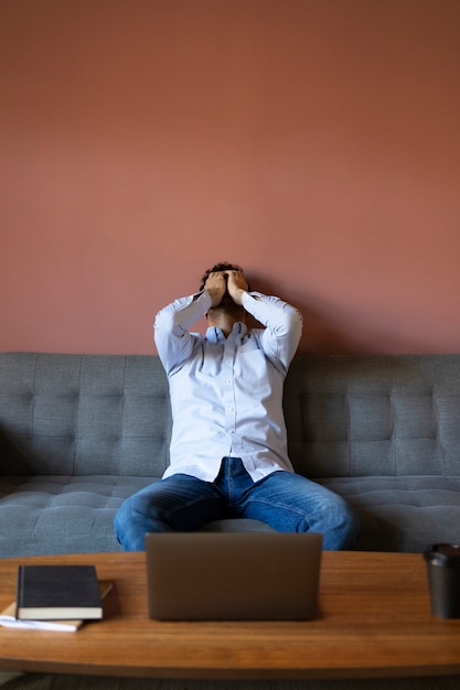 Free photo front view frustrated man on couch