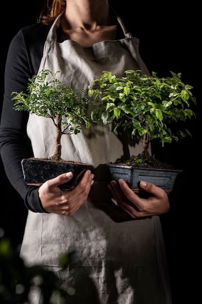 Front view gardener holding potted plants