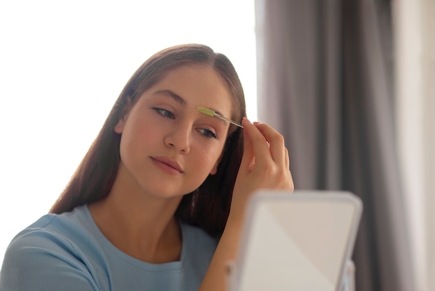 Foto gratuita ragazza di vista frontale che fa le sue sopracciglia