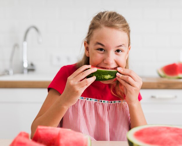 Front view of girl eating watermelon