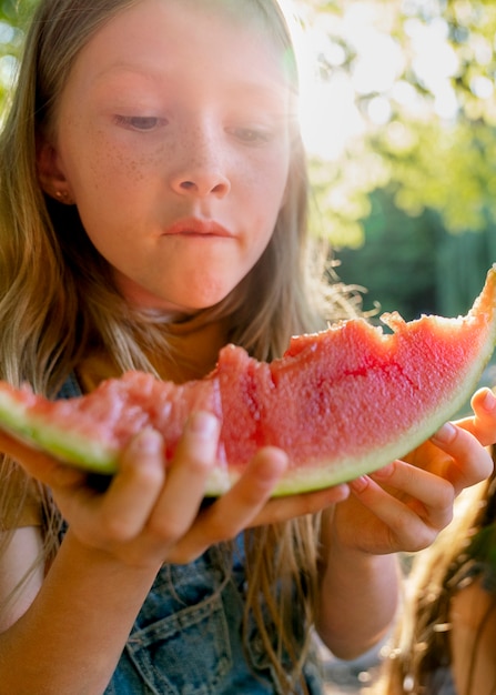 Free photo front view girl eating watermelon