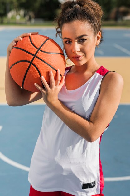 Вид спереди девушка держит баскетбольный мяч