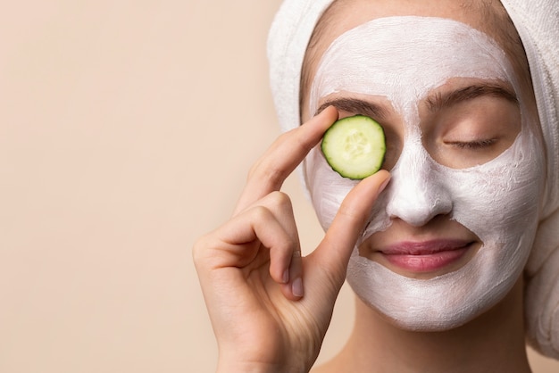 Front view girl holding cucumber slice