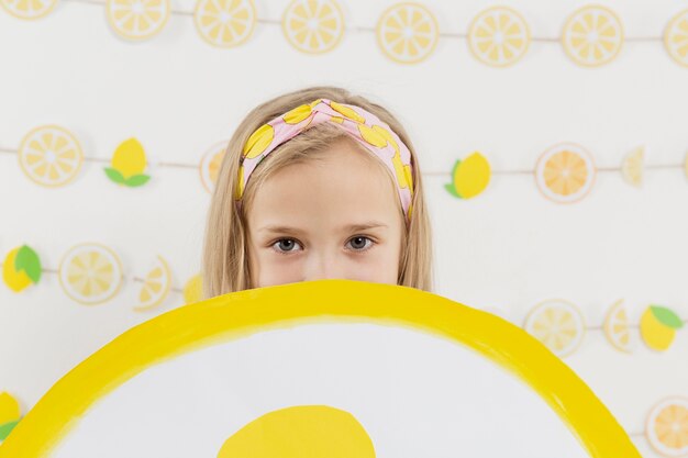 Вид спереди девушка держит украшение ломтик лимона