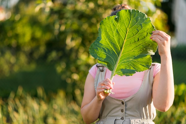 Front view girl holding lettuce leaf