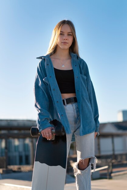 Front view girl holding skateboard